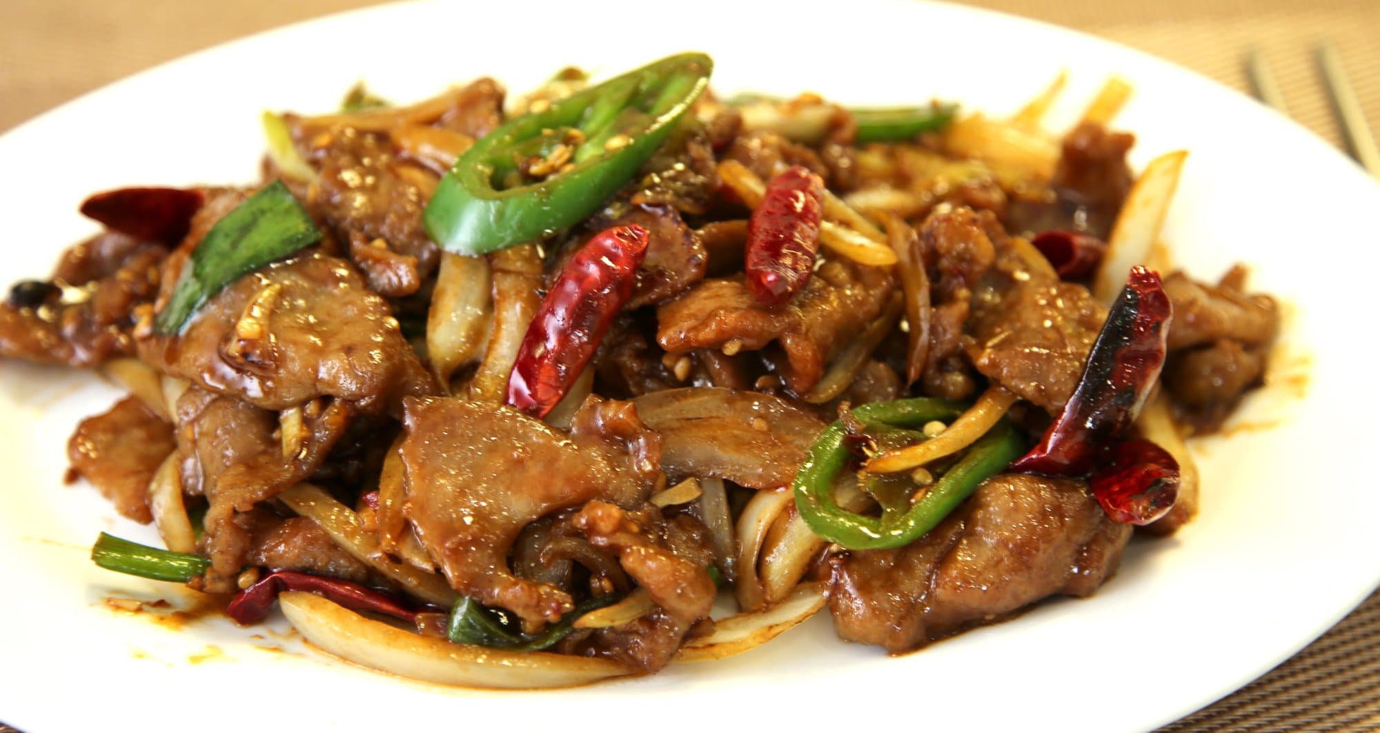 Mongolian Beef - Thinly sliced beef stir-fried with green onions, garlic, onions jalapeño and a s | Meat